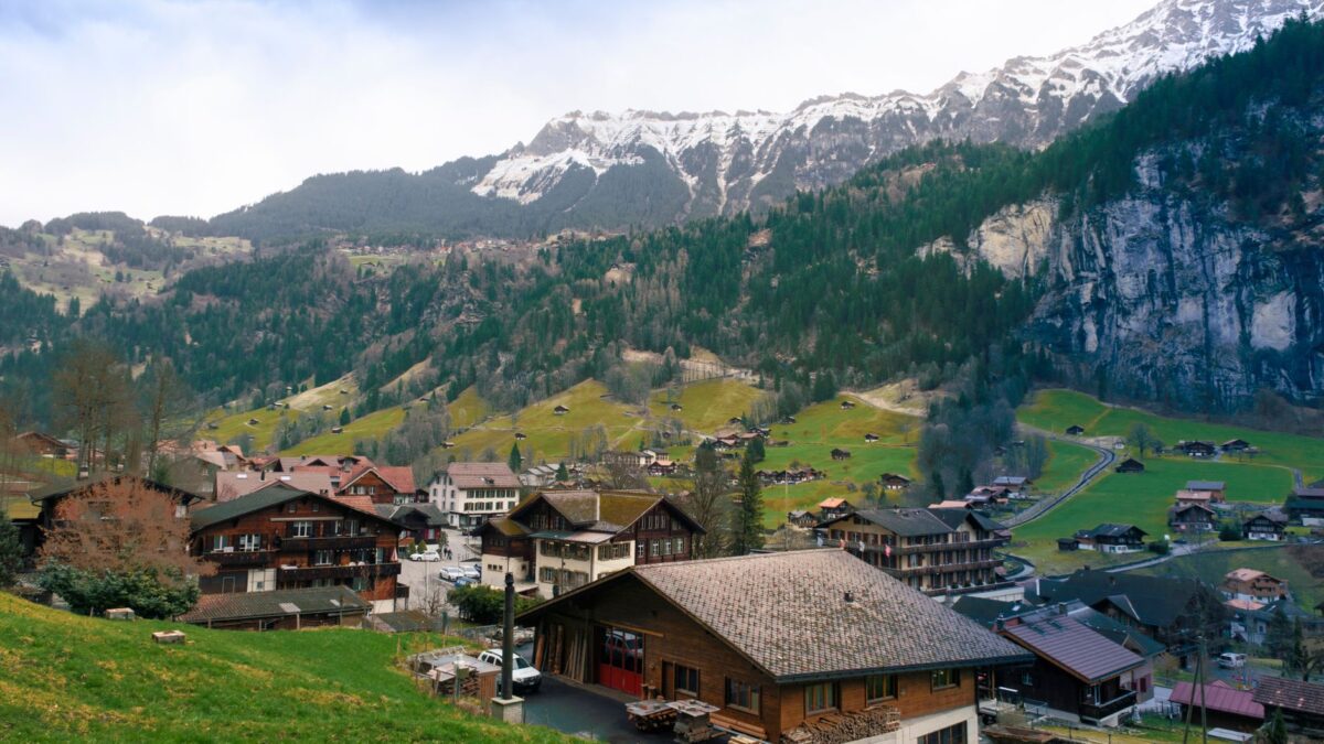 Wohnhäuser in einem Schweizer Dorf vor Bergkulisse