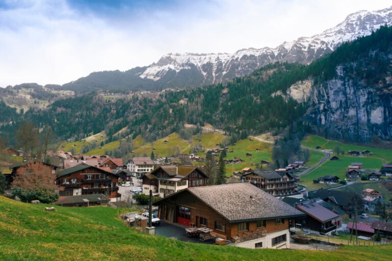 Wohnhäuser in einem Schweizer Dorf vor Bergkulisse